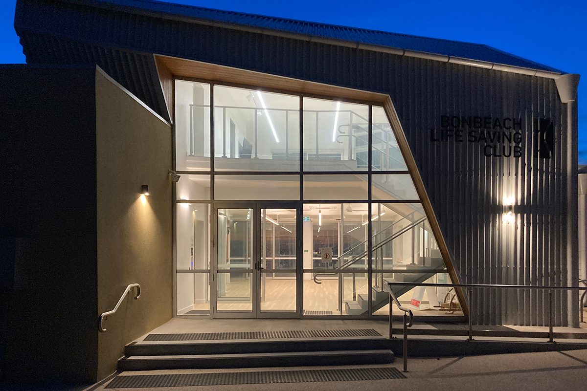 Bonbeach Life Saving Club entrance lighting with modern glass facade at night.