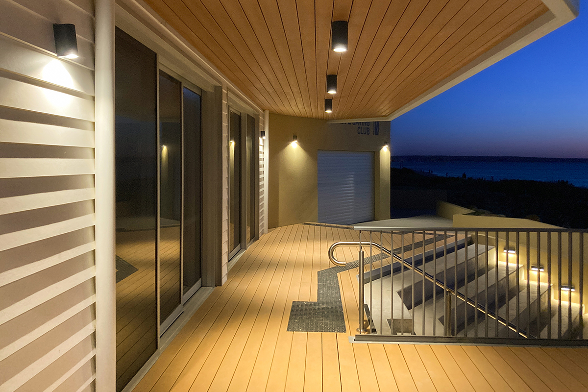 Bonbeach Life Saving Club exterior walkway lighting with coastal view at dusk.