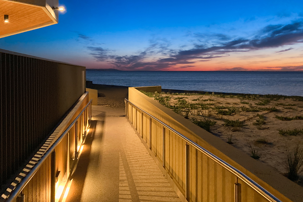 Coastal walkway lighting at Bonbeach Life Saving Club overlooking the beach at sunset.