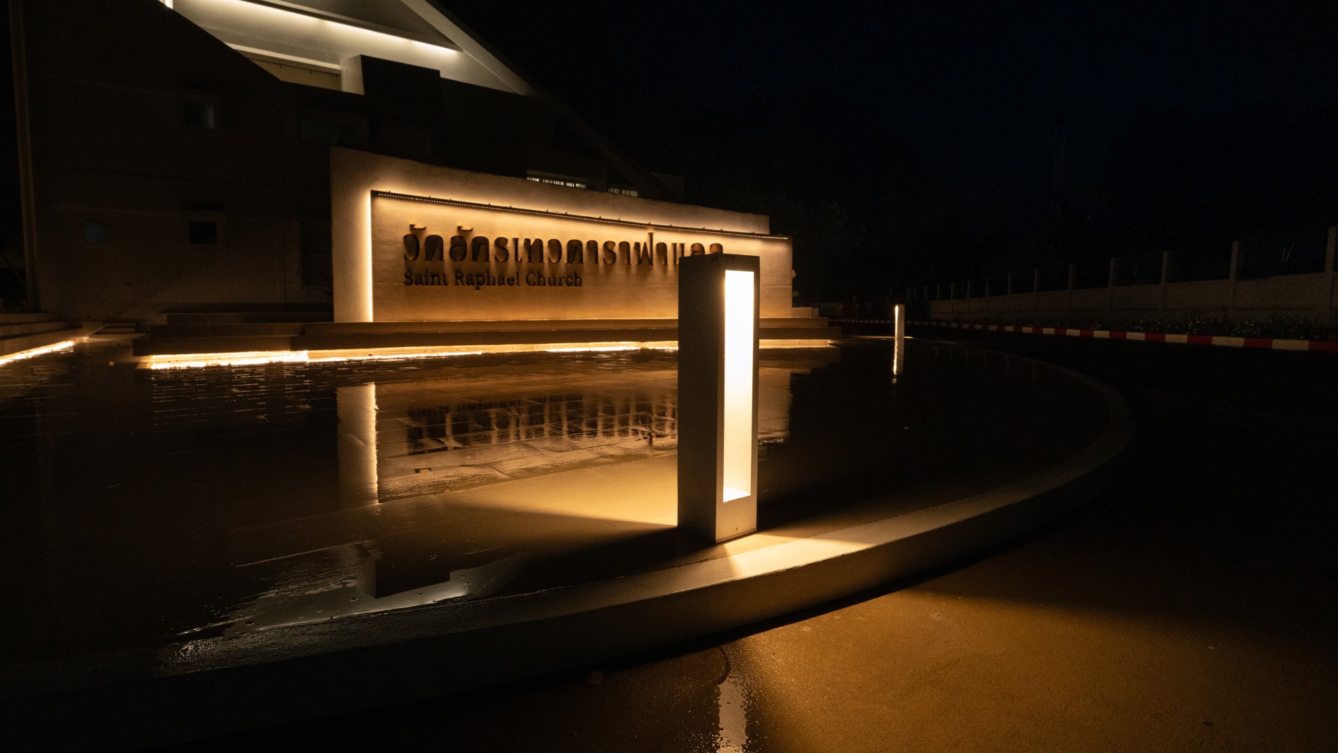 Illuminated entrance signage of St. Raphael Catholic Church at night