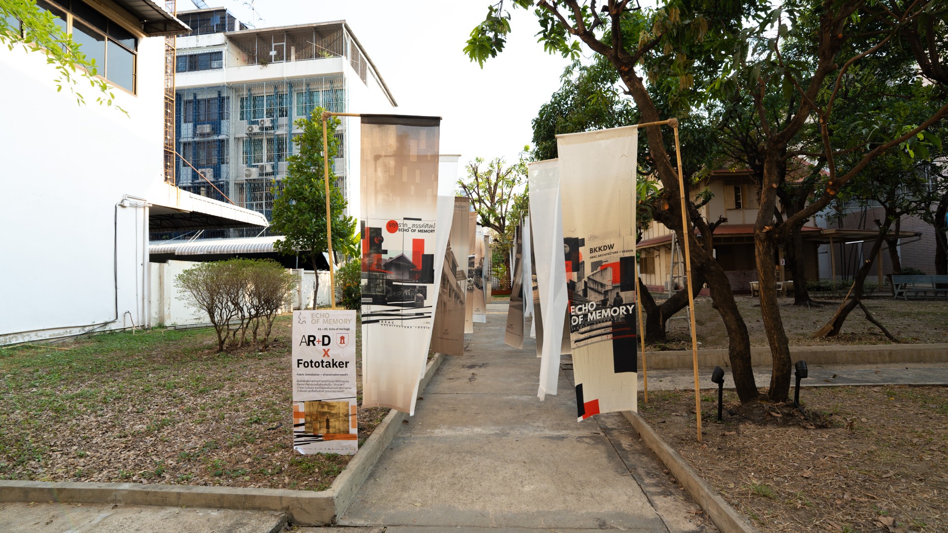 Entrance walkway of the Echoes of Memory exhibition featuring graphic panels and outdoor lighting.