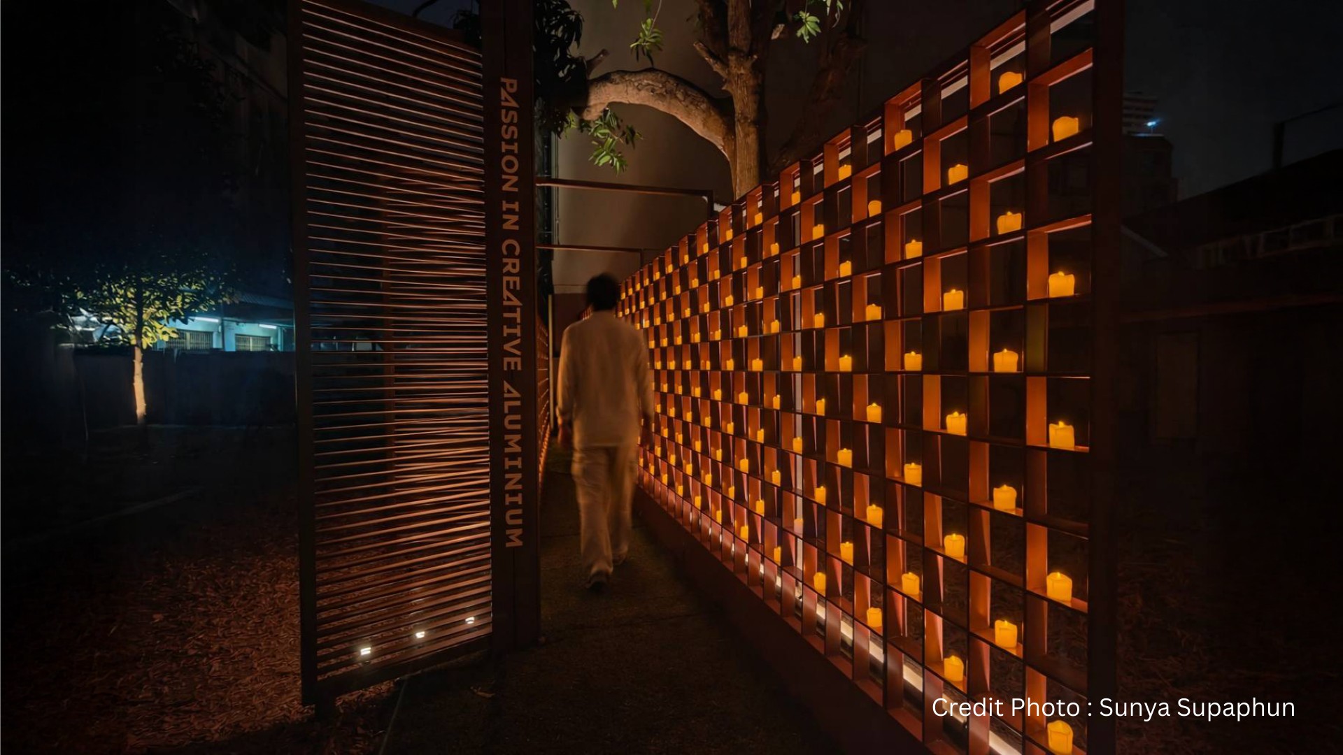 Illuminated installation walkway at Bangkok Design Week featuring warm architectural lighting and modular panels.