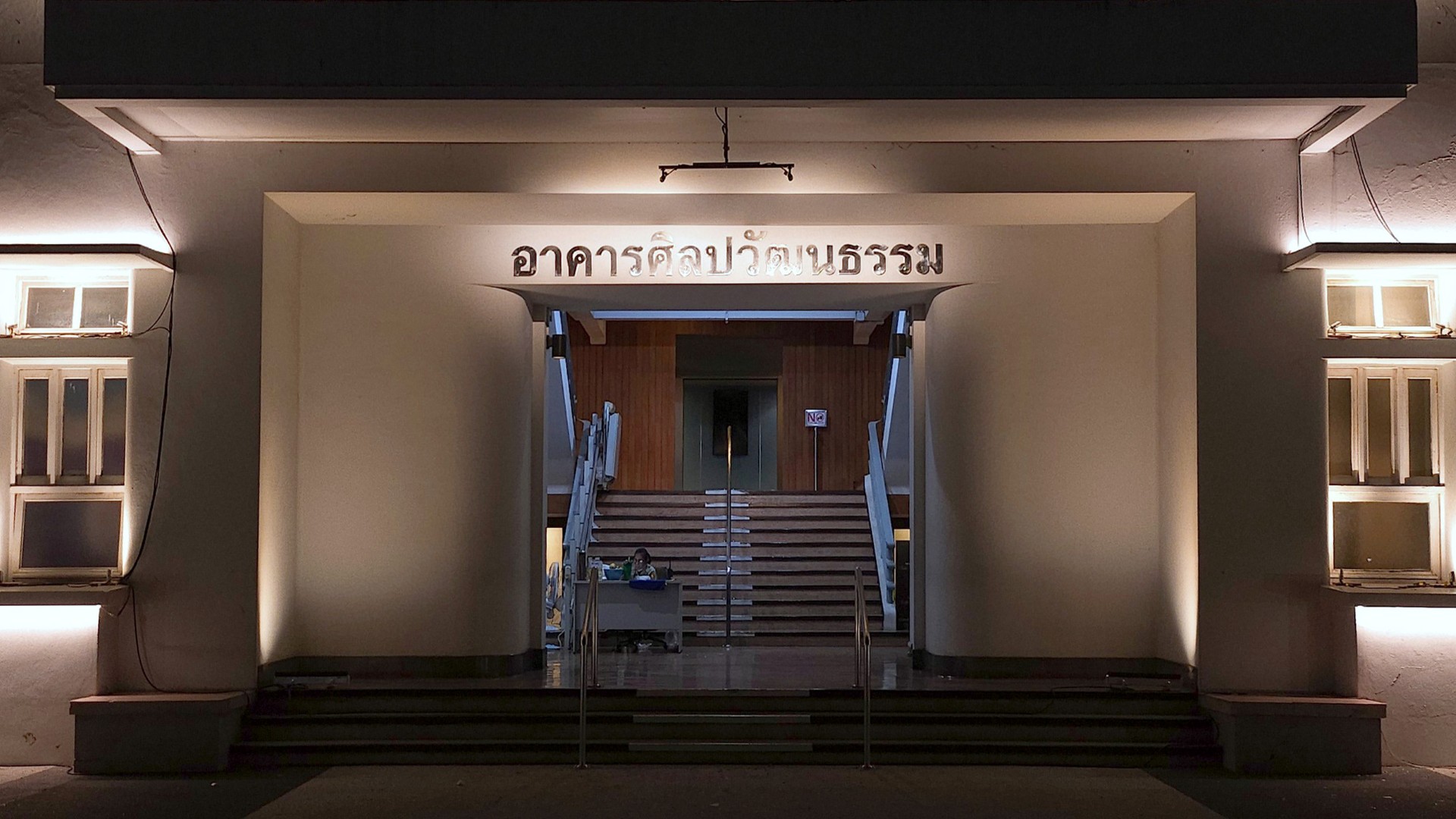 Illuminated university entrance with façade uplighting and signage lighting