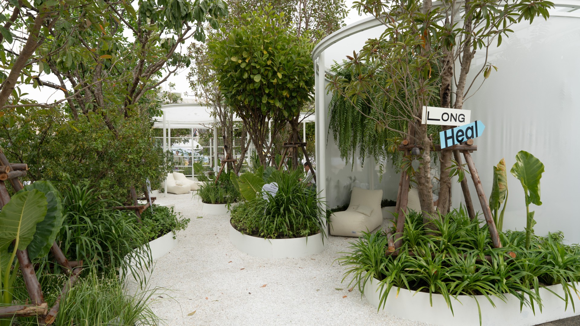 Urban forest installation at SHMA Long Heal exhibition, Bangkok Design Week 2026, featuring green landscape and public seating
