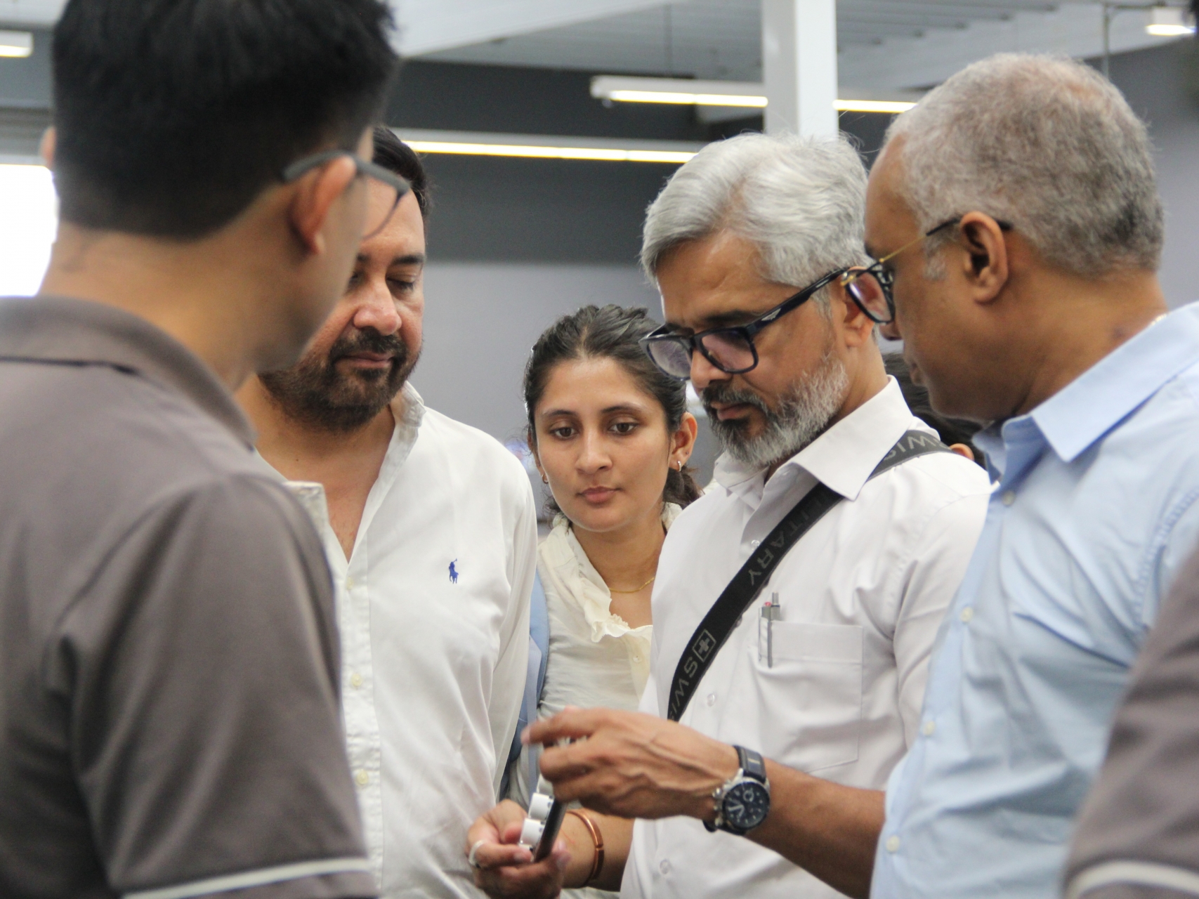 Zion Dzine representatives examining a lighting component during their visit to the Unilamp facility.