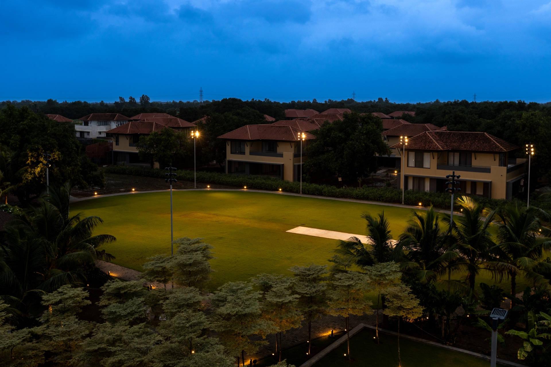Sports lawn at Awadh Ayuska illuminated with Unilamp SONIC floodlights and landscape luminaires for evening use.