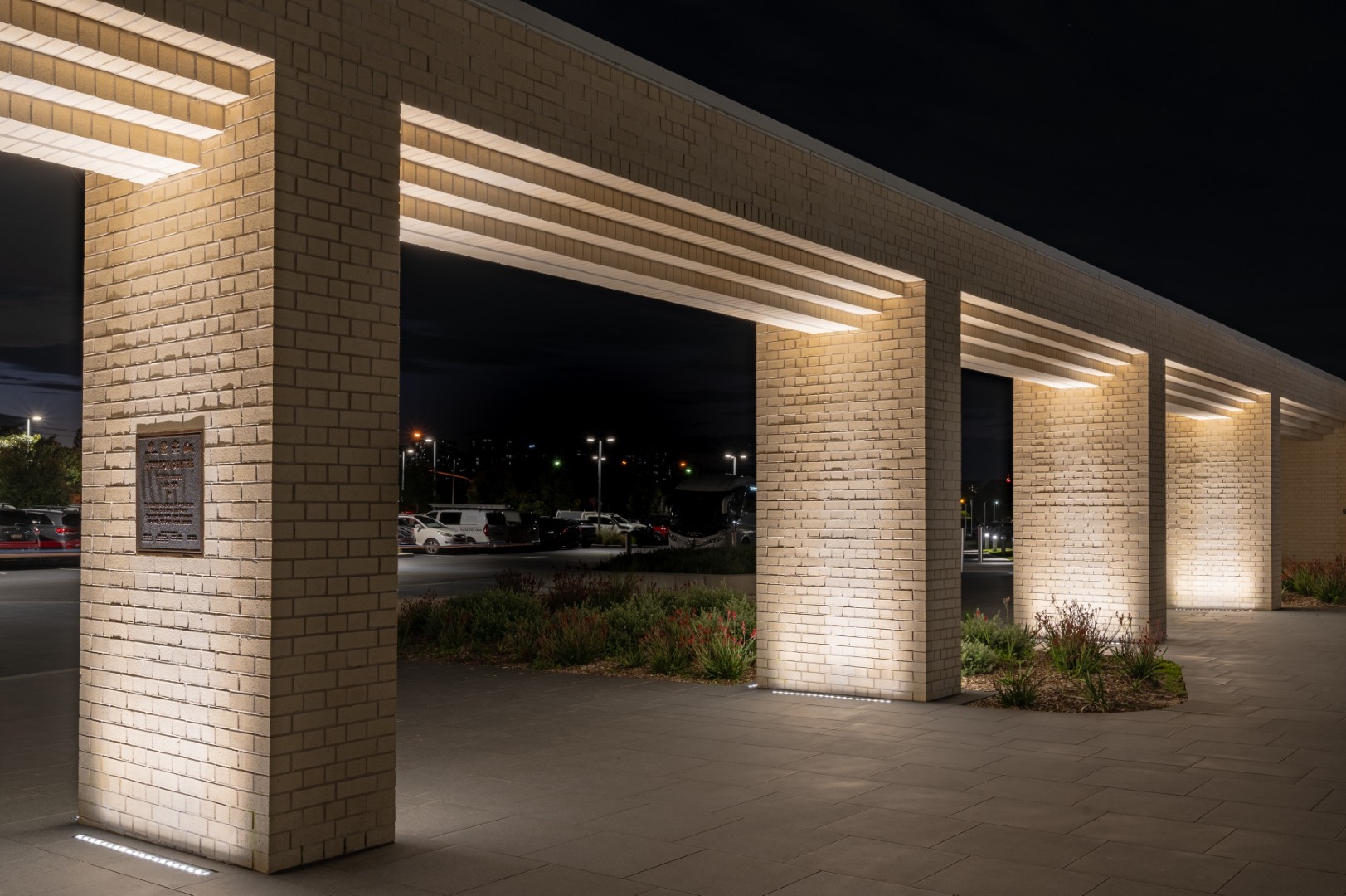 Exterior brick columns highlighted by linear inground lighting at Heffron Centre