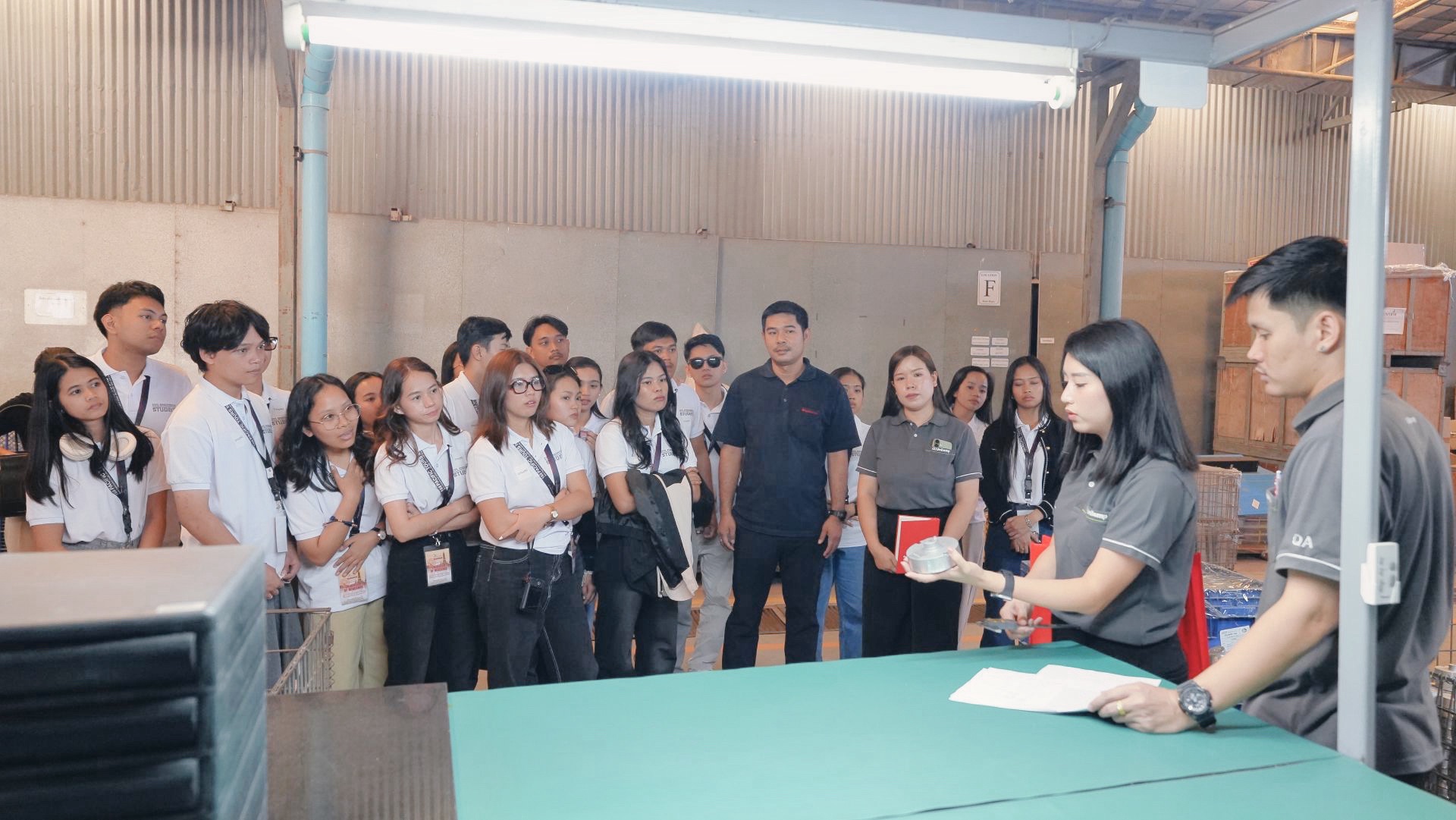 University of Mindanao engineering students observing a product demonstration during the Unilamp factory tour.