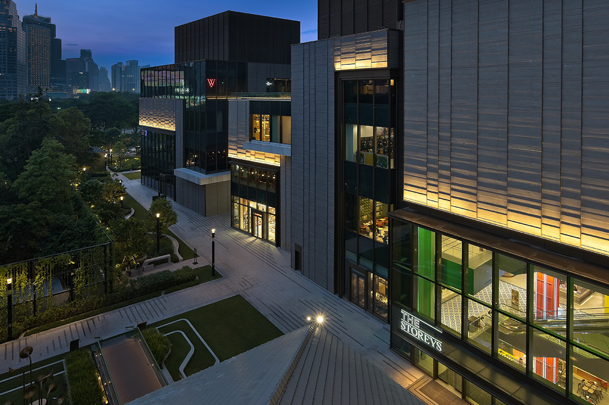 Exterior night view of One Bangkok building with warm facade lighting and glass windows.